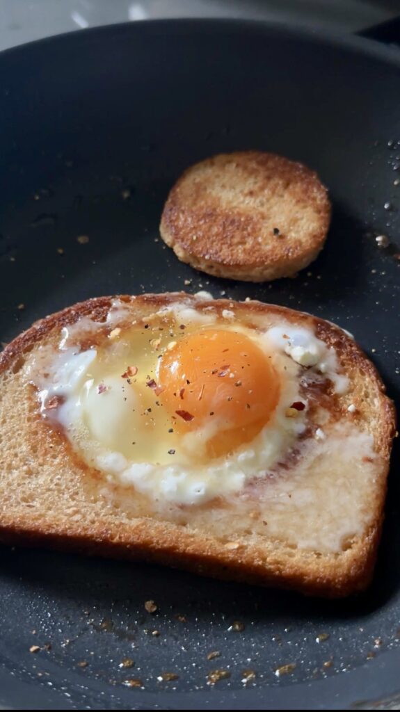 feta fried egg-in-a-hole cooking in a skillet