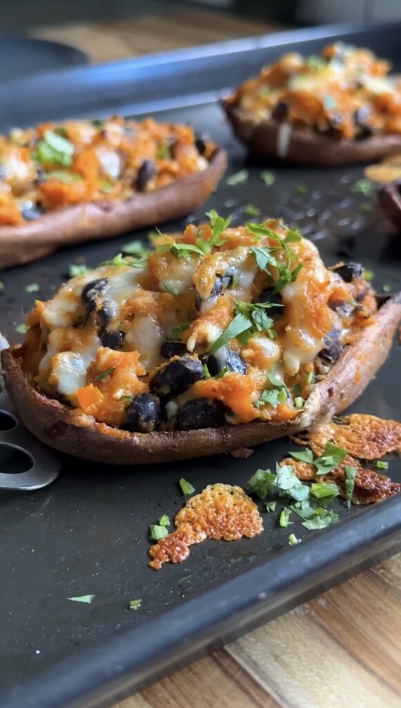 high-protein sweet potato boats on a black baking sheet