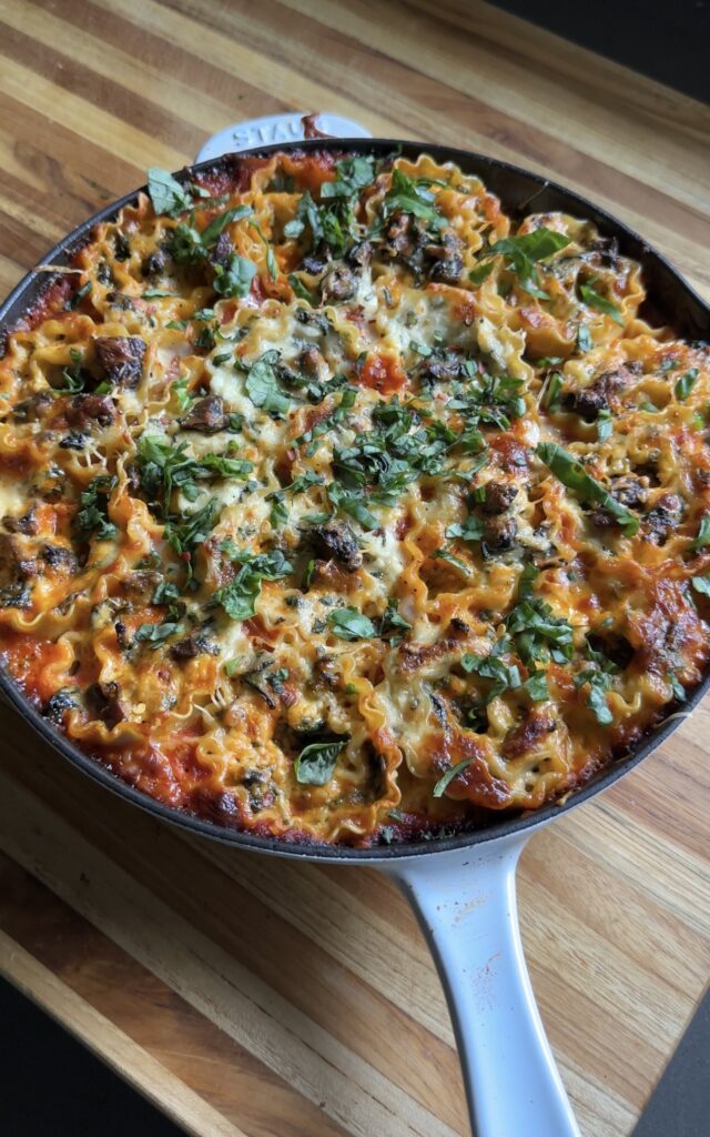 skillet lasagna roll-ups are placed on a wooden cutting board