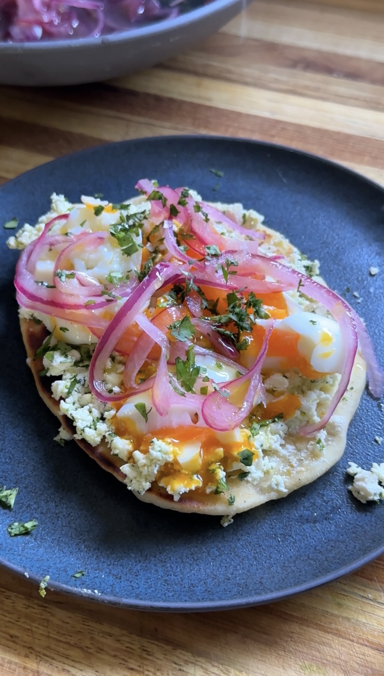 Smashed feta with egg and pickled red onions atop mini naan.