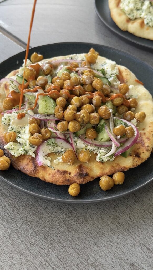 grilled yogurt flatbreads with crispy chickpeas on a black plate