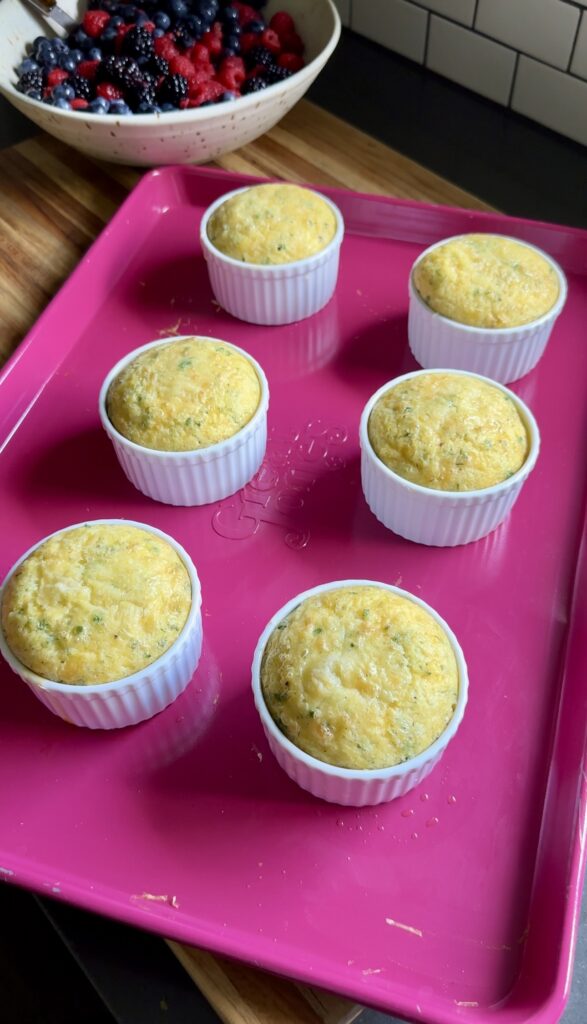 mini egg bakes sitting on a pink baking sheet