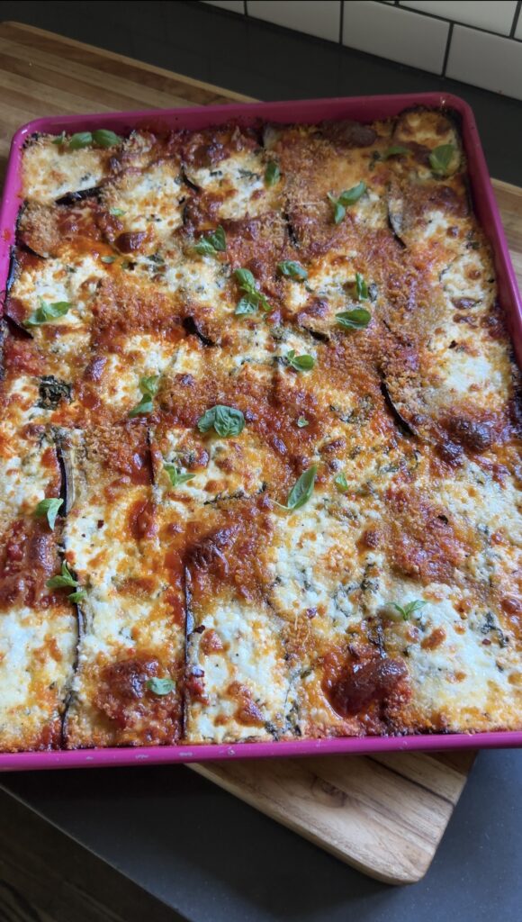 sheet pan eggplant parmesan on a wooden cutting board