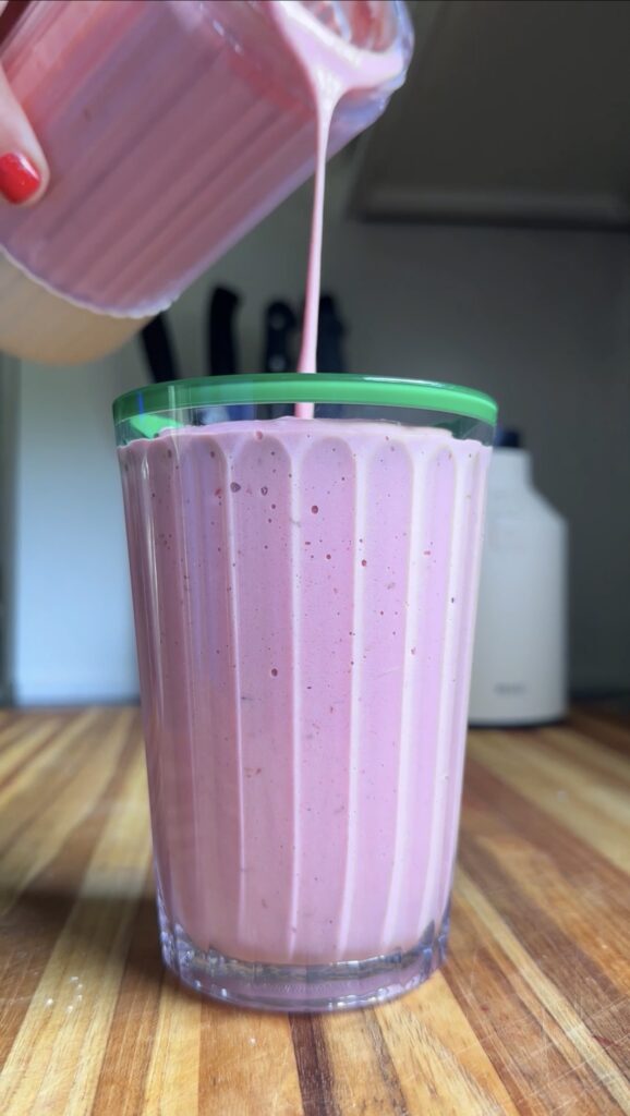 cup being filled with raspberry-mango protein smoothie