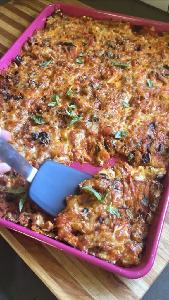 a slice of spaghetti squash alla norma being scooped up with a spatula