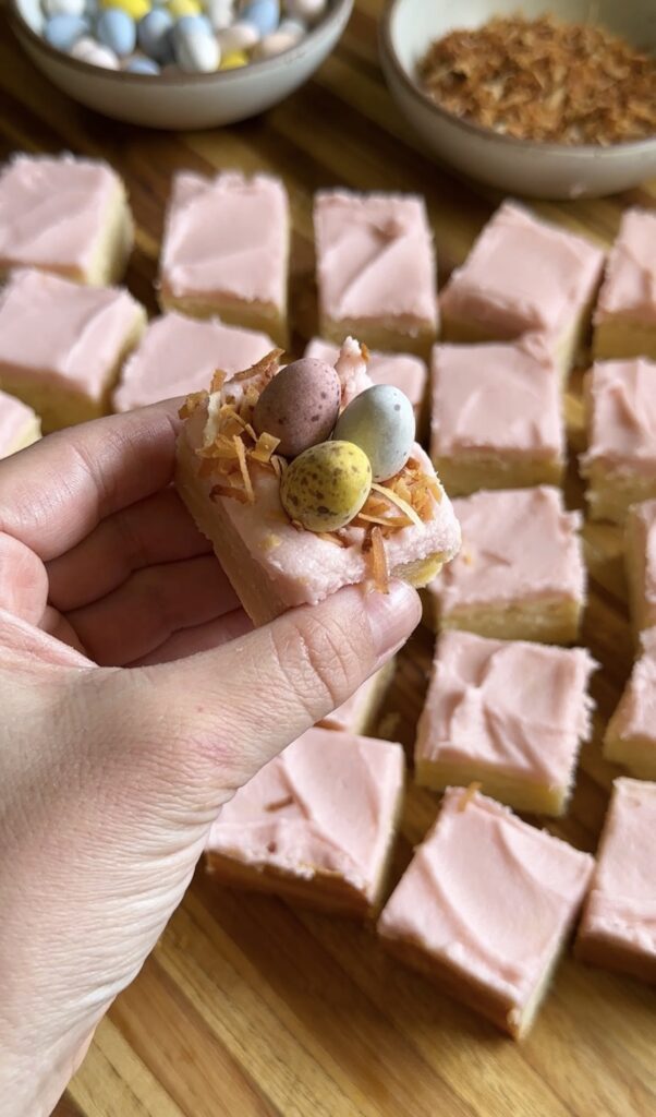 hand holding frosted sugar cookie bite