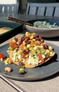 smashed feta tostadas with corn and bean salsa on outdoor table