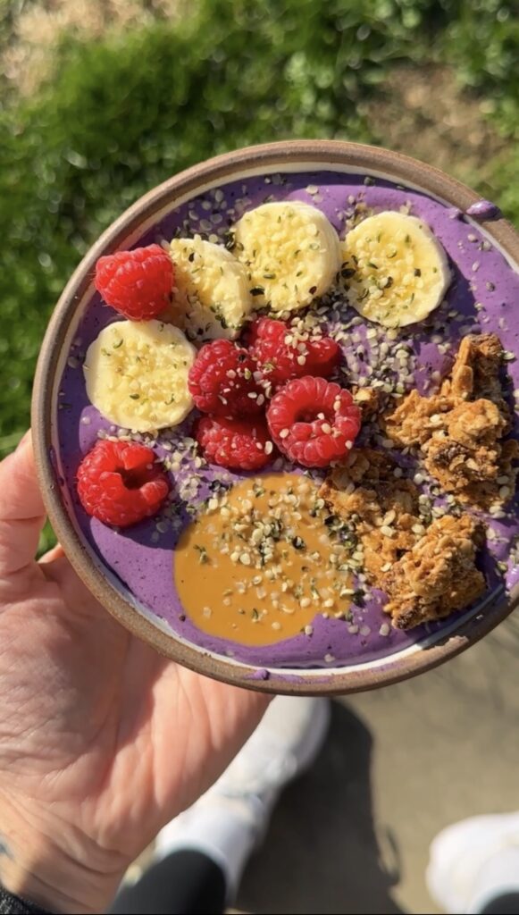 hand holding purple smoothie bowl