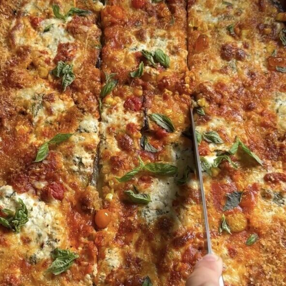 hand slicing into sheet pan summer veggie parmesan