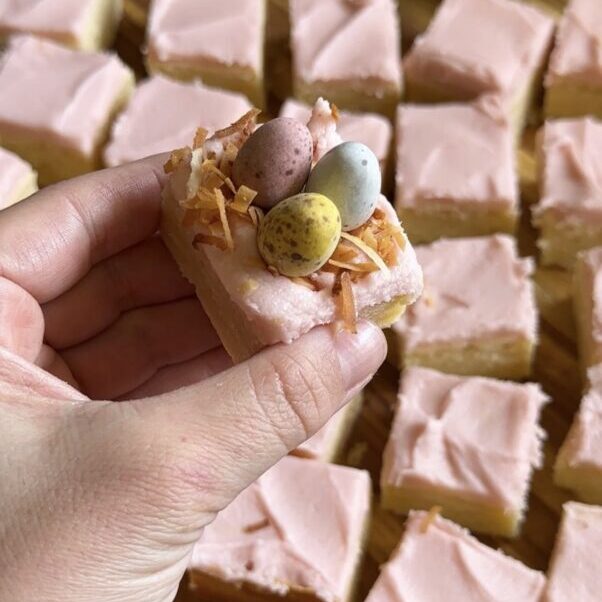 hand holding frosted sugar cookie bite