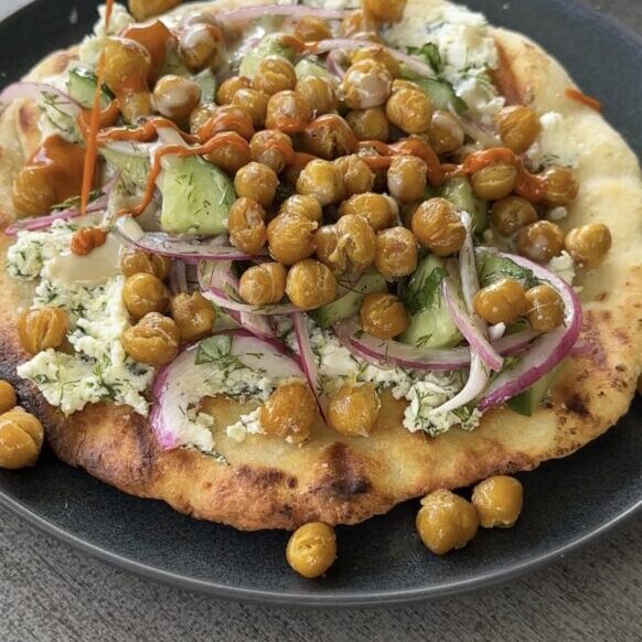 grilled yogurt flatbreads with crispy chickpeas on a black plate