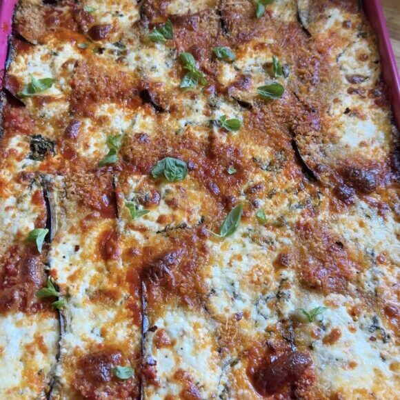 sheet pan eggplant parmesan on a wooden cutting board