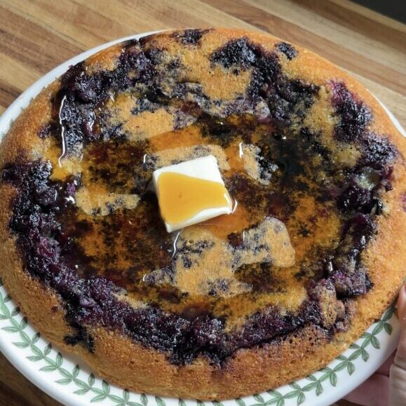 giant cottage cheese blueberry pancake with a pat of butter on top