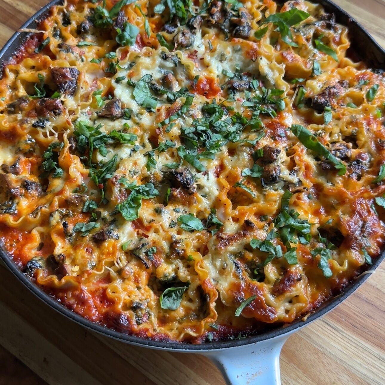skillet lasagna roll-ups are placed on a wooden cutting board