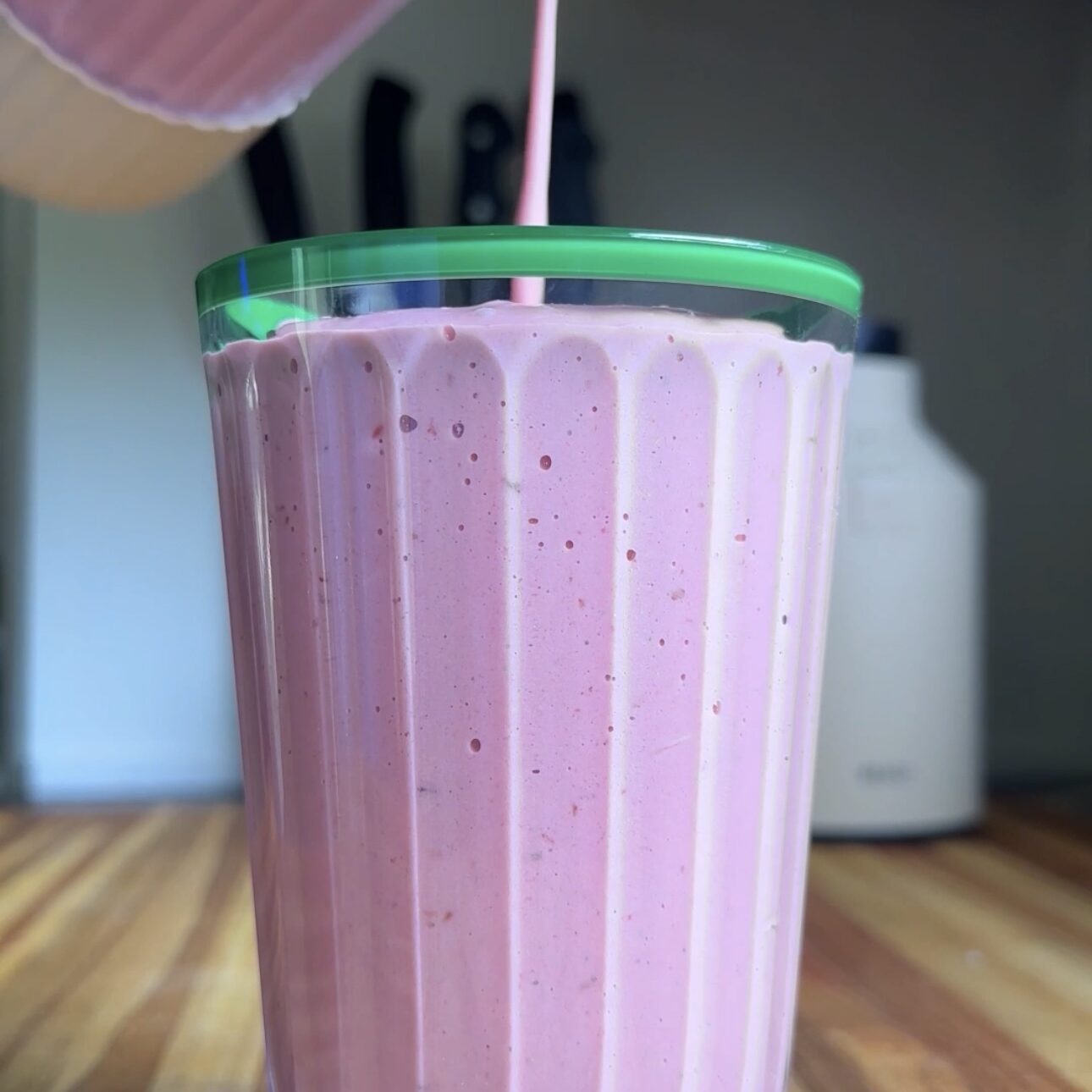 cup being filled with raspberry-mango protein smoothie