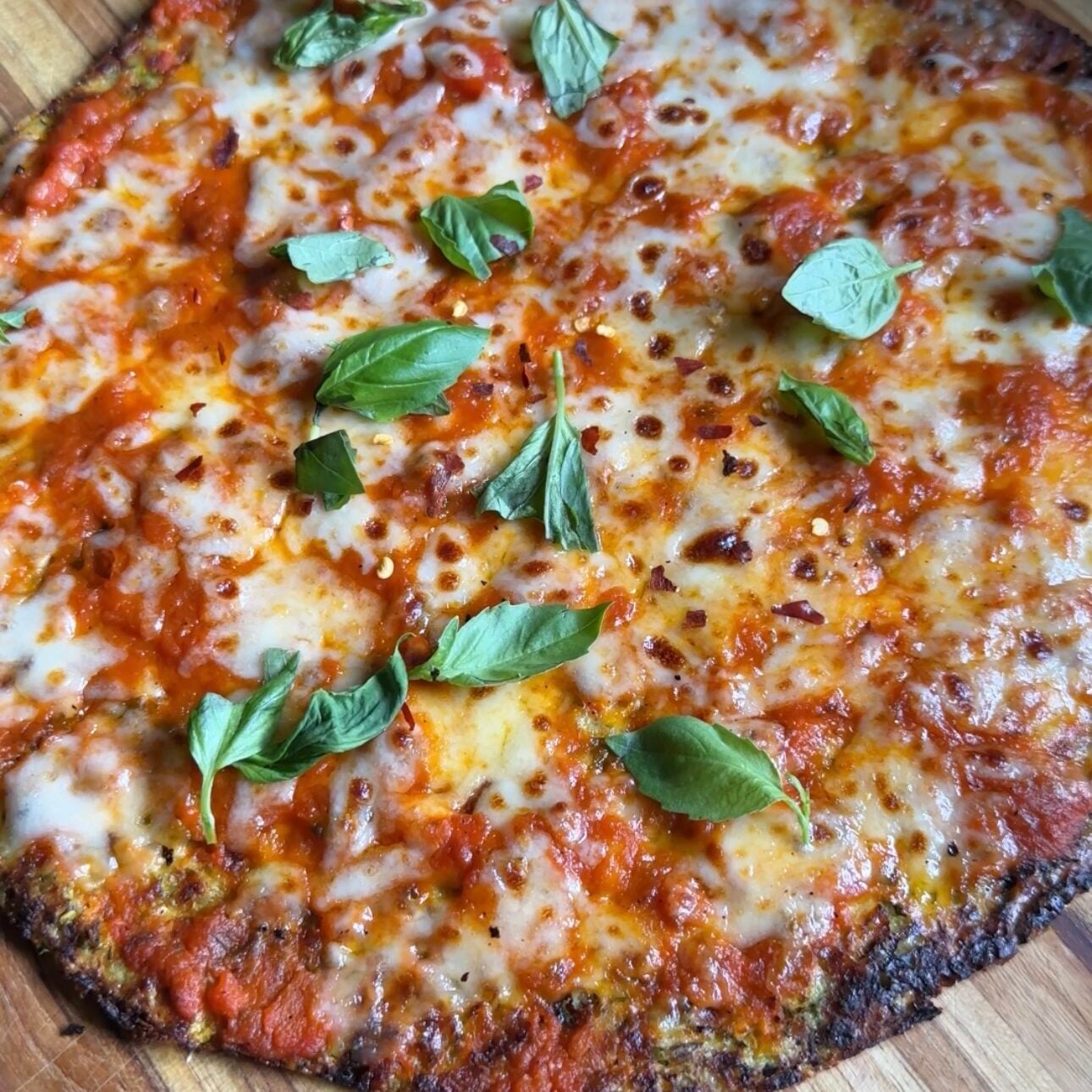 whole zucchini cottage cheese pizza sitting on a wooden cutting board